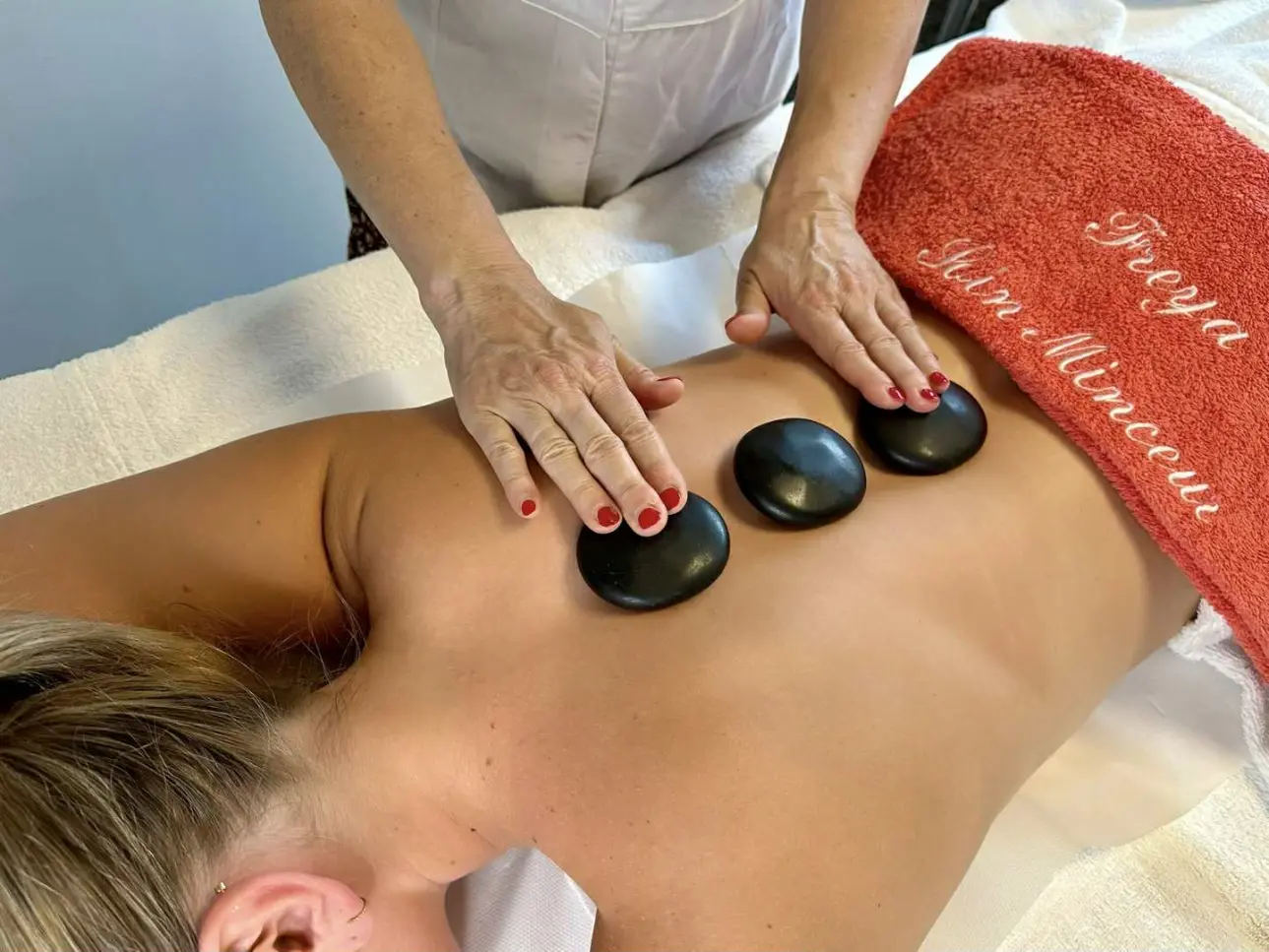Femme allongée en train de recevoir un massage relaxant dans un espace bien-être Freya
